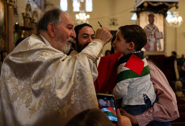 Criança envolvida em bandeira palestina vai a igreja em Santiago do Chile