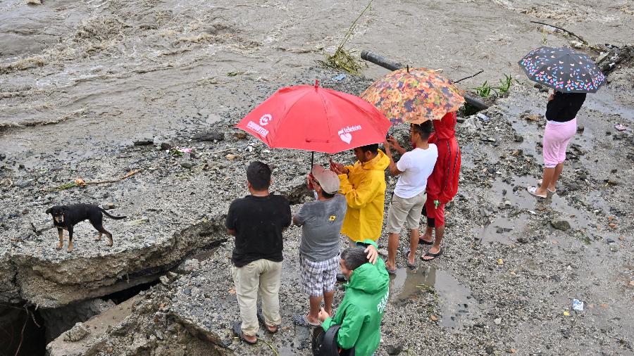 Pessoas olhando para enxurrada perto de San Pedro Sula, em Honduras, depois da tempestade tropical Sara