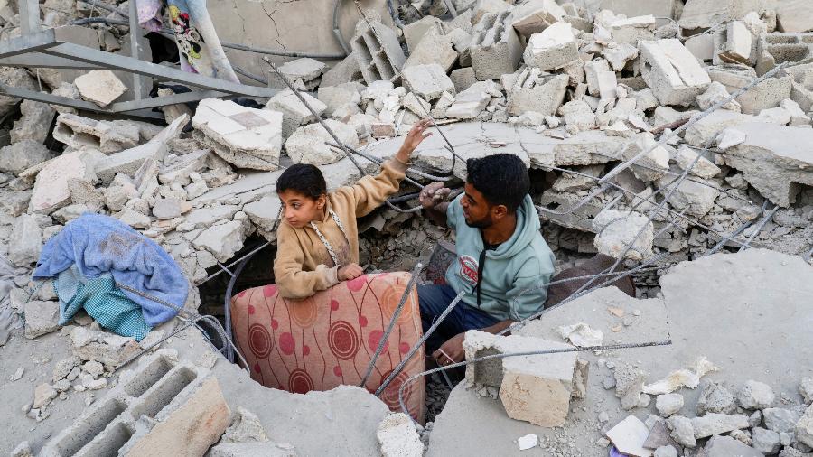 22.abr.2025 - Palestinos em meio a escombros de uma casa após ataque israelense em Khan Younis, no sul da Faixa de Gaza 22.abr.2025 - Palestinos em meio a escombros de uma casa após ataque israelense em Khan Younis, no sul da Faixa de Gaza
