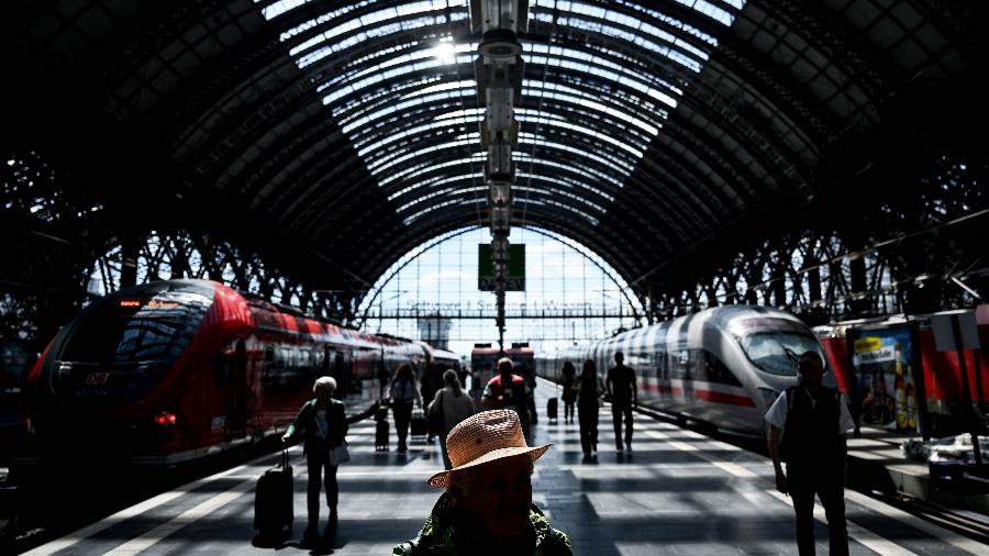 Passengers walk on a platform past ICE high speed train (R) and regional train at main railway station in Frankfurt am Main, western Germany, on May 20, 2025. (Photo by Kirill KUDRYAVTSEV / AFP)