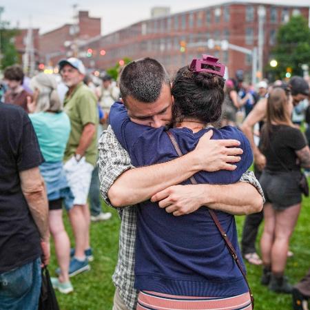 13.jul.2026 - Pessoas se abraçam no vigília feita após a morte de homem alvejado por agentes do ICE em Biddeford, Maine