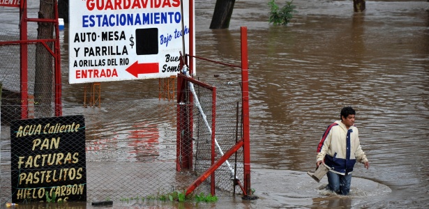 Homem caminha por via inundada em Luján, na província de Buenos Aires, na quinta-feira (6) - Carlos Brigo/TELAM/Xinhua