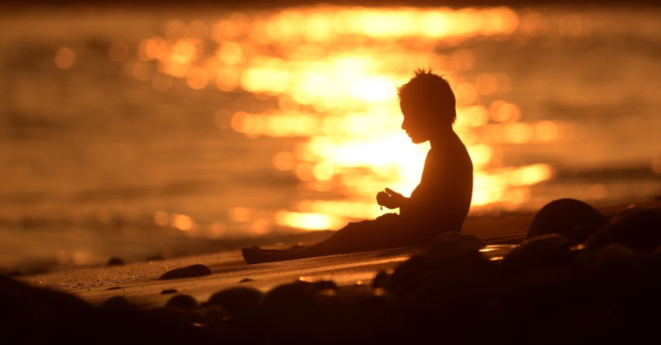 18.set.2015 - Um menino brinca na praia El Tunco durante o pôr do sol em La Libertad, em San Salvador (El Salvador)