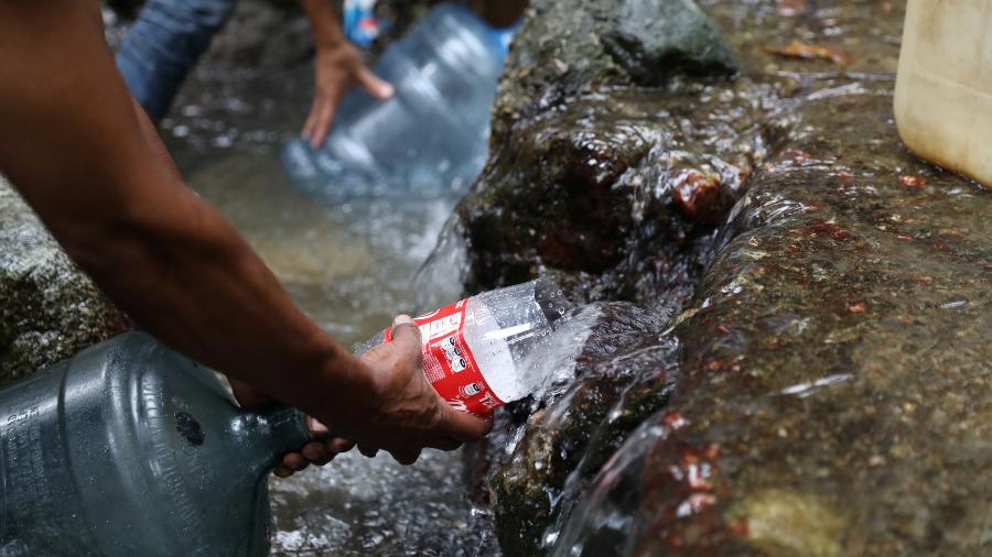 31.mar.2019 - Pessoas enchem garrafas com água do rio em Caracas, Venezuela - Manaure Quintero/Reuters