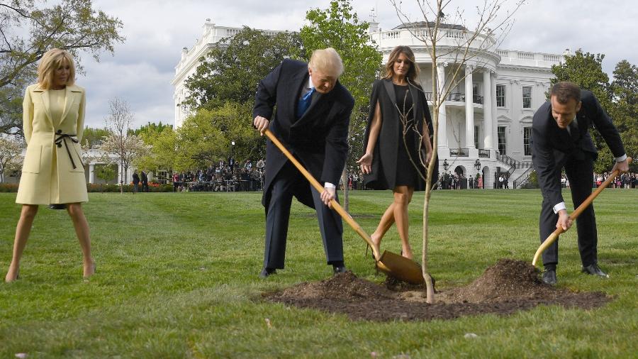 23.abr.2018 - O presidente dos Estados Unidos, Donald Trump, e o presidente francês, Emmanuel Macron, plantam uma árvore na Casa Branca  - JIM WATSON/AFP