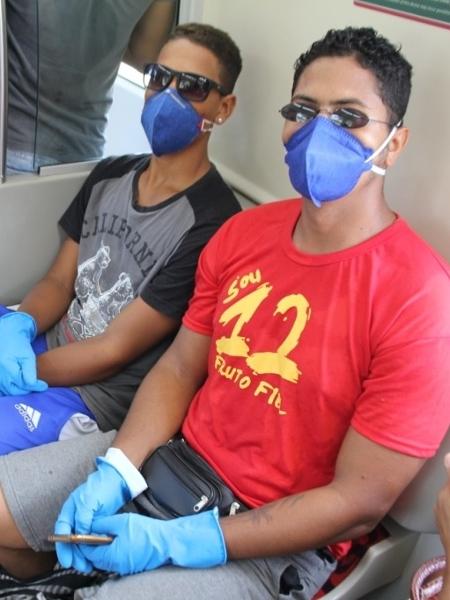 Os irmãos Jadson e Jonas Araújo usam máscaras de carpinteiro e luvas de borracha no metrô de Salvador - Aurélio Nunes / UOL