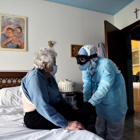Um médico em traje de proteção visita uma pessoa que sofre da doença de coronavírus em sua casa em Bergamo, o epicentro do surto da Itália - FLAVIO LO SCALZO/REUTERS