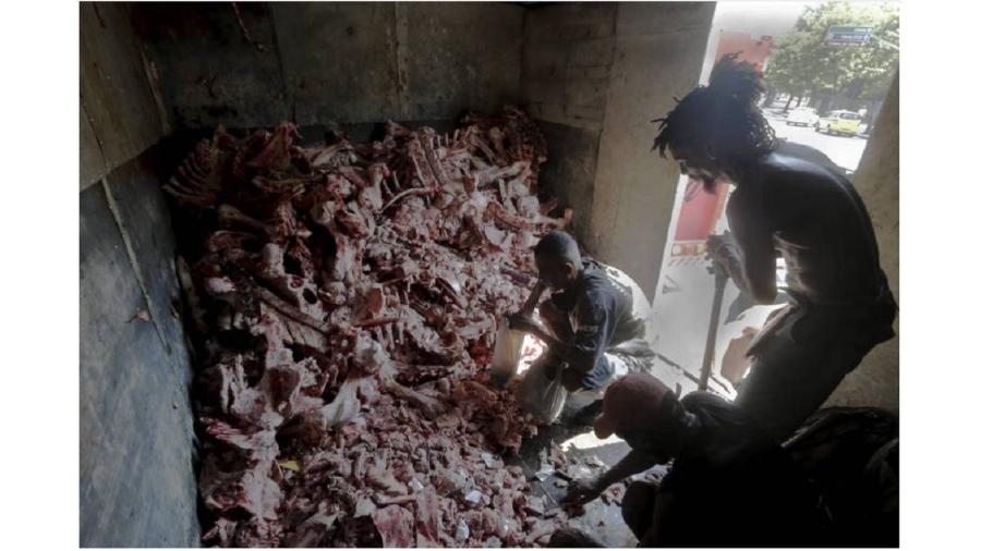 Famintos buscam restos de carne em caminhão de ossos no Rio. Cena se repete em outros cidades do país - Domingos Peixoto/Agência O Globo