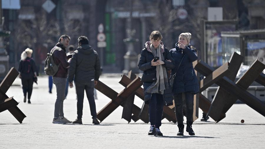 16.abr.2021 - Pedestres caminham em meio a obstáculos antitanque em Kiev, na Ucrânia - Genya Savilov/AFP
