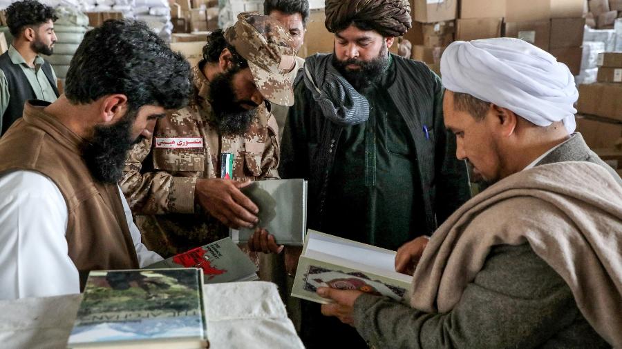 Fotografia tirada em 12 de novembro mostra funcionários do governo talibã avaliando livros importados do Irã para o Afeganistão  - MOHSEN KARIMI/AFP