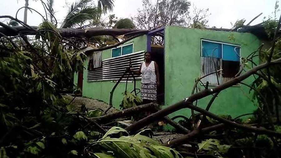 Moradora de uma casa danificada pela passagem do ciclone Harold em Vanuatu, também no Pacífico Sul - O. UMUUMULOVO/AFP