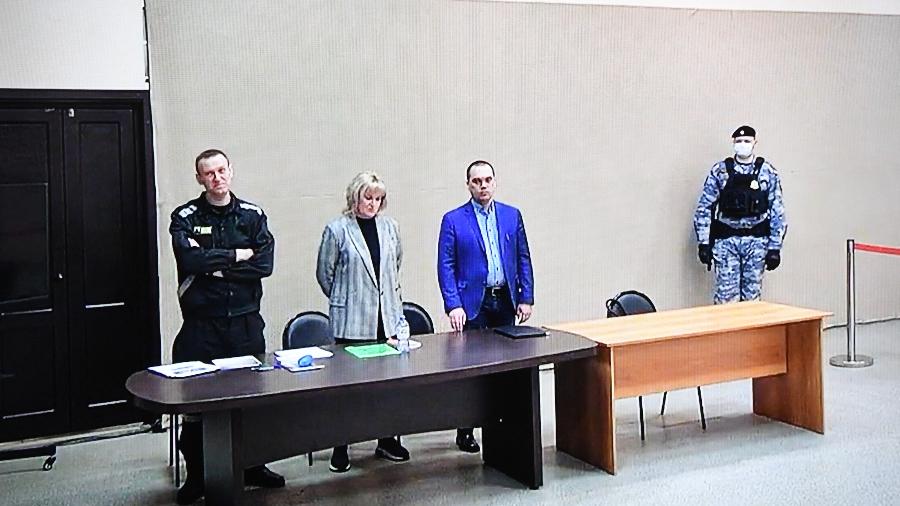 22.mar.2022 - O líder da oposição russa, Alexei Navalny (à esquerda), é visto em uma tela por meio de um link de vídeo durante julgamento na colônia prisional IK-2 na cidade de Pokrov, na região de Vladimir - AFP