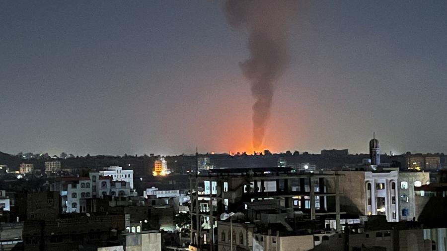 Fumaça sobe no céu após ataques aéreos liderados pelos EUA em Sanaa, Iêmen, 25 de fevereiro de 2024