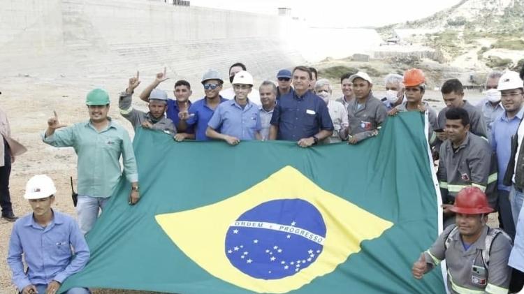 Trabalhadores fizeram um L com os dedos durante visita de Bolsonaro em 2021 Trabalhadores fizeram um L com os dedos durante visita de Bolsonaro em 2021