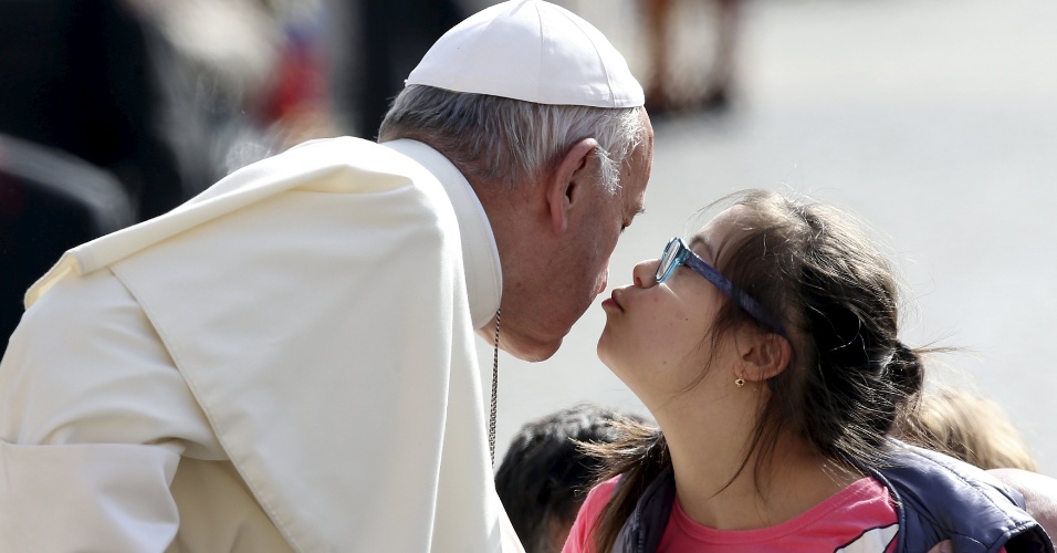 6.abr.2016 - Papa Francisco recebe um beijo de uma criança durante a sua chegada para a audiência semanal na Praça de São Pedro, no Vaticano