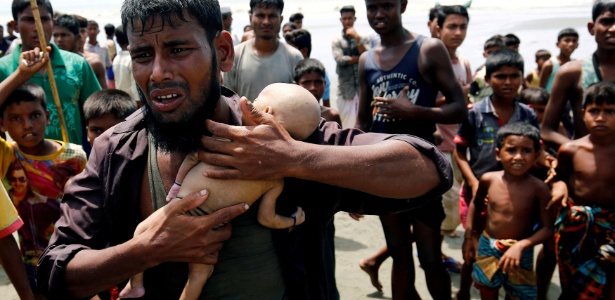 O refugiado Nasir Ahmed, da etnia Rohingya, segura o filho morto nos braços após o barco em que a família estava virar na fuga de Mianmar para Bangladesh - Mohammad Ponir Hossain/Reuters