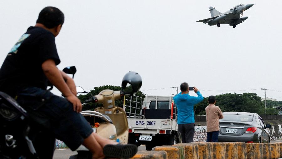 Pessoas olham para uma aeronave Mirage 2000-5 da Força Aérea de Taiwan enquanto se prepara para pousar na Base Aérea de Hsinchu em Hsinchu, Taiwan, 23 de maio de 2024 - Carlos Garcia Rawlins/REUTERS
