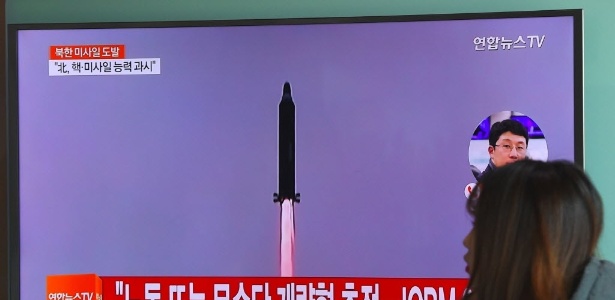 12.fev.2017 - Uma mulher passa por uma tela de televisão mostrando imagens de arquivo do lançamento de mísseis da Coreia do Norte em uma estação ferroviária em Seull - Jung Yeon-Je/AFP