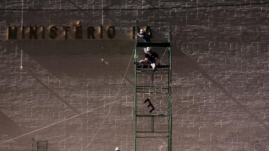 Operários colocam letreiro do Ministério da Economia no prédio onde funcionava o do Trabalho - Pedro Ladeira/Folhapress