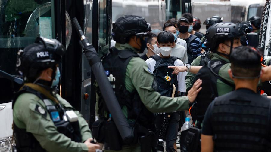 Policiais colocam manifestantes em um ônibus em Hong Kong - TYRONE SIU/REUTERS