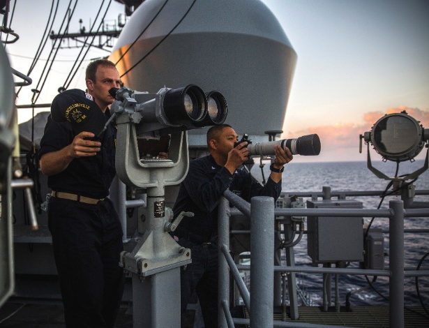 29.ago.2018 - Marinheiros da equipe de coleta de dados do porta-aviões USS Chancellorsville observam e fotografam uma fragata chinesa que os seguia em sua patrulha no mar do Sul da China - Bryan Denton/The New York Times