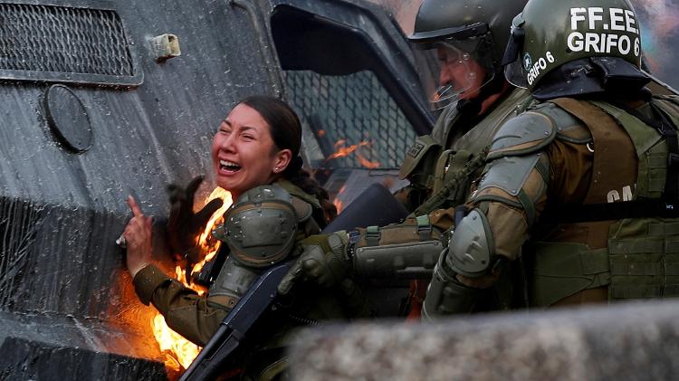 Policial em chamas durante protesto contra o governo do Chile em Santiago