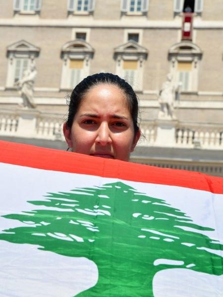Mulher segura bandeira do Líbano enquanto esperava pelo Angelus do papa Francisco neste domingo no Vaticano - Alberto Pizzoli/AFP
