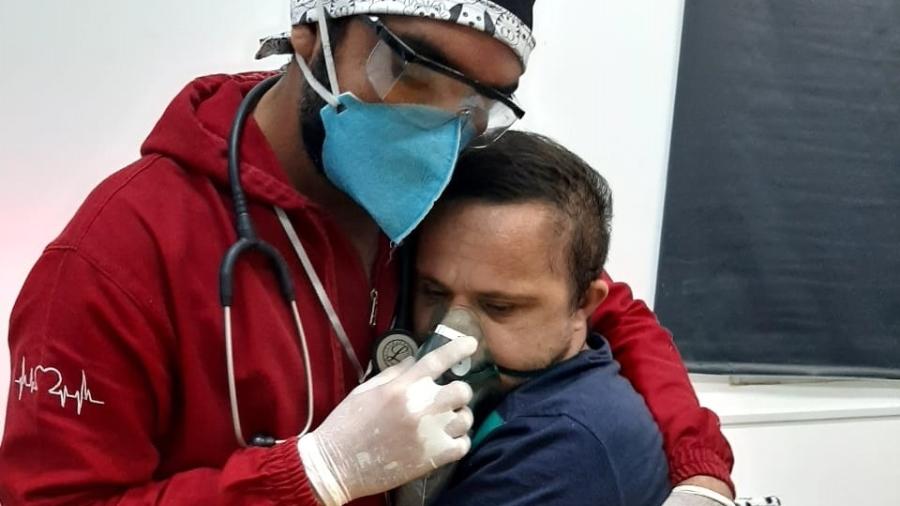 Ao ver o desespero do paciente Émerson Júnior, 30, que temia o uso da máscara com oxigênio, o enfermeiro Raimundo Nogueira Matos, 38, o abraçou - Mirene Borges Da Silva