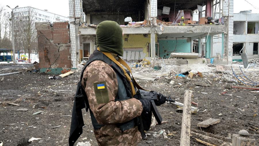 9.mar.2022 - Membro da Forças de Defesa Territoriais da Ucrânia observa as destruições após um bombardeio a Kharkiv - AFP