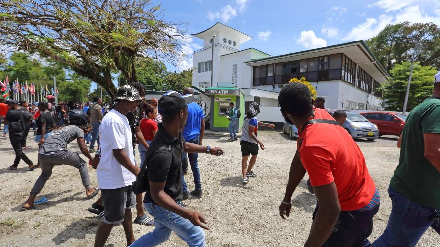 Pessoas atacam a Assembleia Nacional durante um protesto contra as políticas económicas governamentais em Paramaribo, Suriname - Ranu Abhelakh/AFP