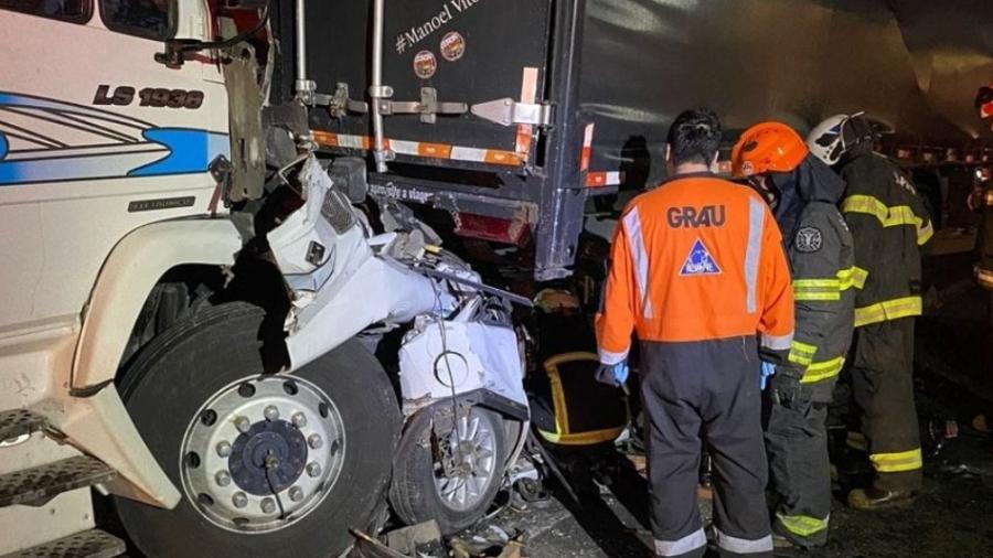 Corpo de Bombeiros retirou duas pessoas com vida de dentro do carro amassado entre caminhões, na Dutra