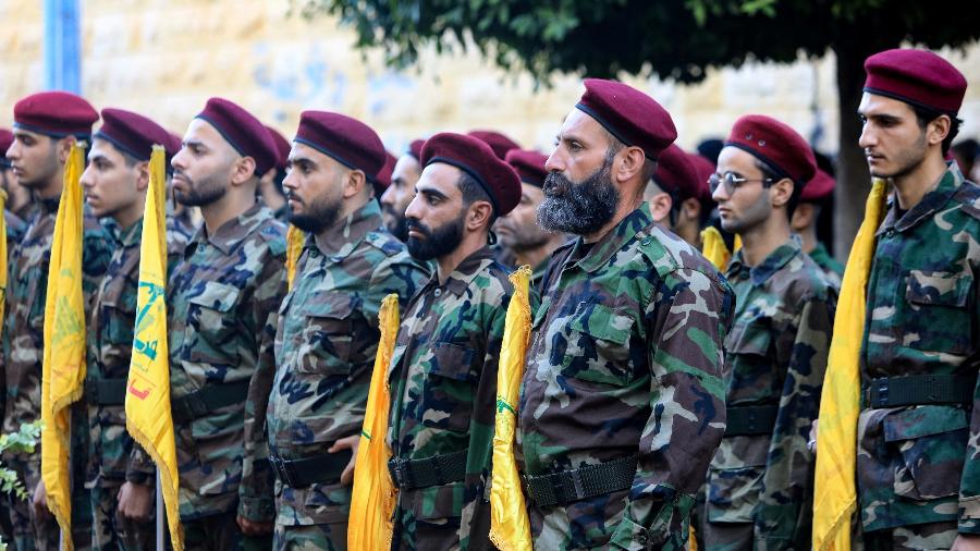 Combatentes do Hezbollah participam do cortejo fúnebre dos comandantes Ibrahim Mohammed Kobeissi e Hussein Ezzedine, mortos em um ataque israelense nos subúrbios ao sul de Beirute