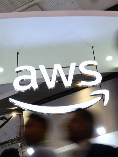 Pessoas andam diante da logo do AWS em congresso de telefonia na Índia Pessoas andam diante da logo do AWS em congresso de telefonia na Índia