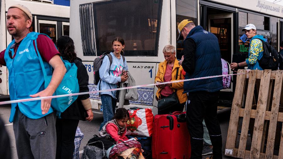 Pessoas evacuadas da fábrica Azovstal de Mariupol chegam em ônibus a uma área de registro e processamento de pessoas deslocadas internamente em Zaporizhzhia, na Ucrânia - Dimitar DILKOFF / AFP