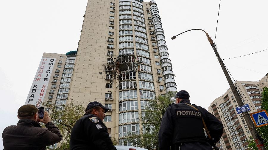 08.mai.23 - Policiais ao lado de um prédio danificado por restos de um drone suicida abatido durante ataque noturno russo em Kiev, Ucrânia - VALENTYN OGIRENKO/REUTERS