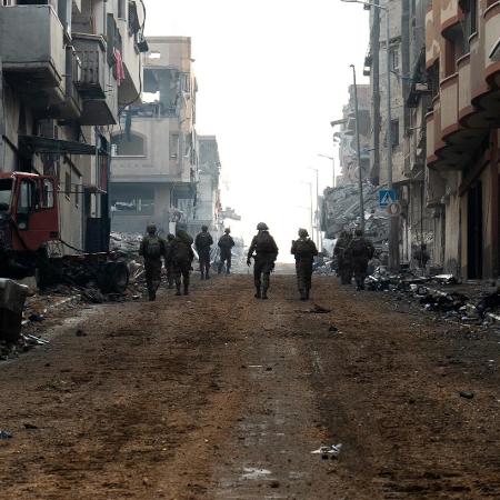 Soldados de Israel caminha pelas ruas destruídas da Faixa de Gaza