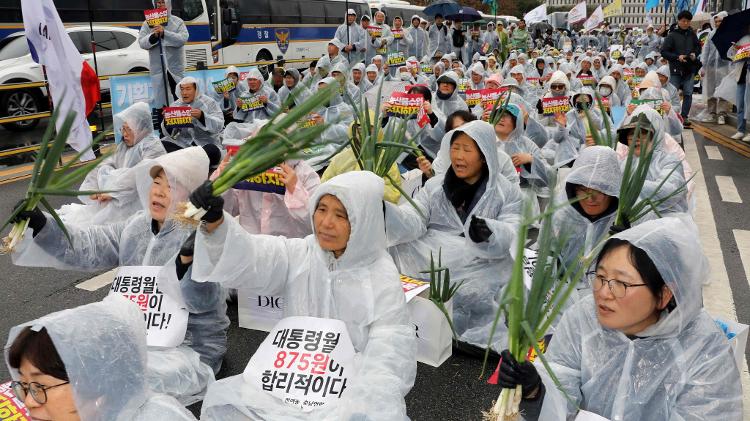 Agricultores sul-coreanos levam cebolinhas a protesto, em 25 de março de 2024