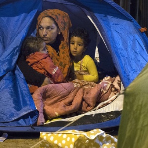 Refugiada síria fica em tenda com seus filhos enquanto espera ser removida para um campo na França - Joel Saget/AFP
