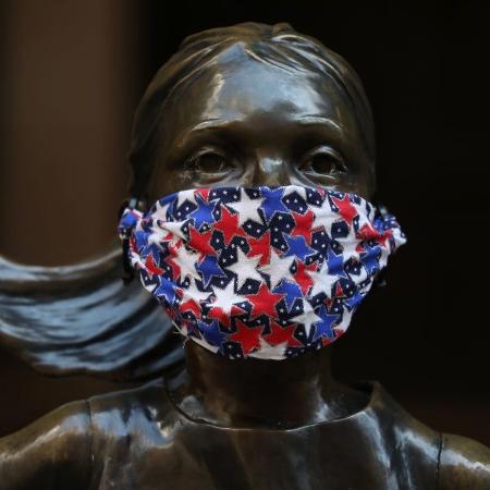 28.abr.2020 - Estátua da "Fearless Girl", em Nova York (EUA), usa máscara para se "proteger" do novo coronavírus - Rob Kim/Getty Images
