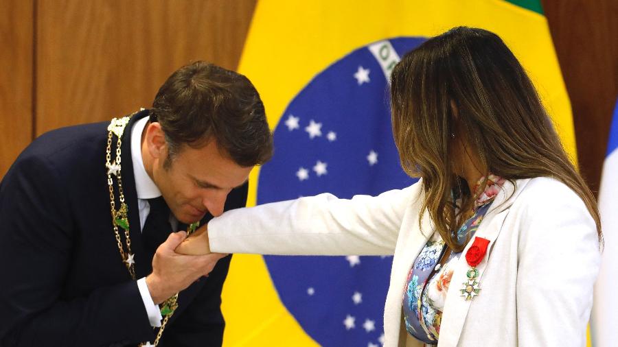 O presidente francês Emmanuel Macron cuprimenta a primeira-dama do Brasil, Janja, após ser receber do governo federal  Ordem Nacional do Cruzeiro do Sul - Sergio Lima - 28.mar.24/AFP