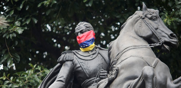 Bandeira da Venezuela cobre o rosto de estátua do herói nacional Simon Bolívar em praça de Caracas - Andres Martinez Casares/ Venezuela