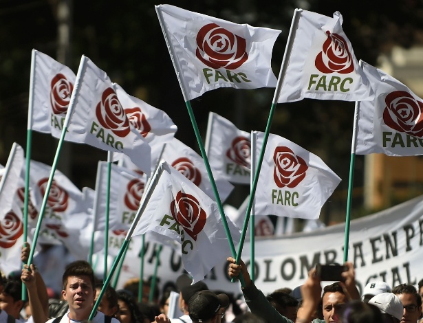 Simpatizantes agitam bandeiras com o logo do partido político Farc, em Bogotá - Raul Arboleda/ AFP
