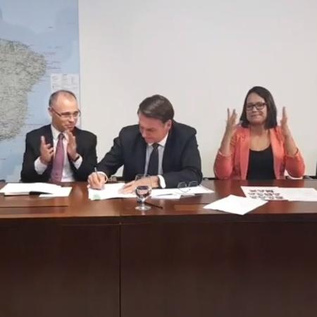 25.abr.2019 - Presidente Jair Bolsonaro assina parecer da AGU (Advocacia-Geral da União) ao lado de André Luiz de Almeida Mendonça, advogado-geral da União - Reprodução