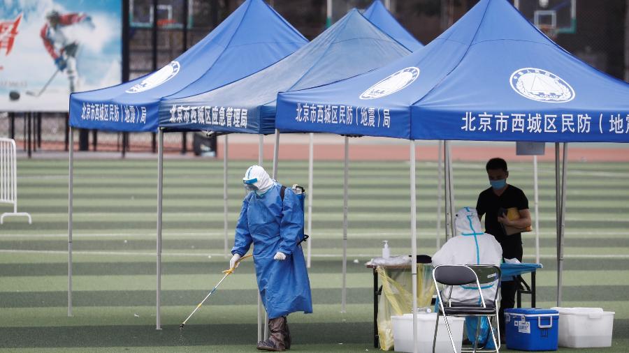 Homem usa spray desinfetante em local de teste para detectar Covid-19 em Pequim - 