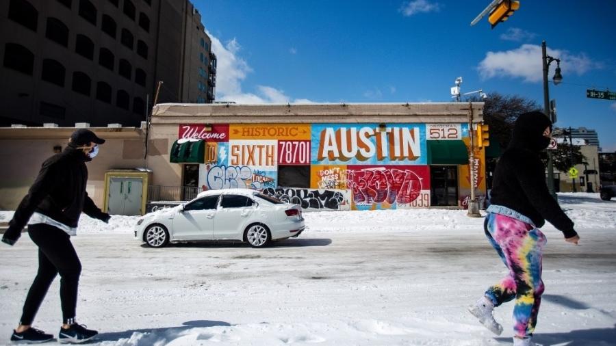 Pedestres caminham em uma rua coberta por neve em Austin, no Texas - 15.fev.2021 - Montinique Monroe/AFP