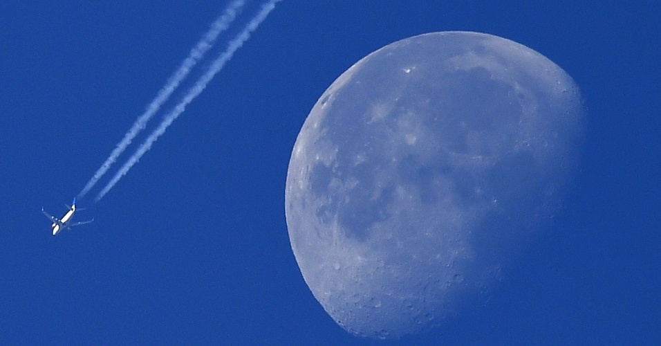 2.out.2015 - Avião passa ao lado da Lua ao sobrevoar a cidade de Londres, na Inglaterra