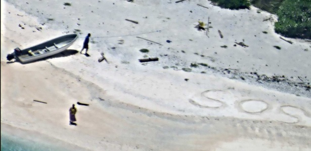 Um casal preso há uma semana na ilha de East Fayu, na Micronésia, foi resgatado depois que um avião que participava de sua busca avistou um sinal de S.O.S. escrito na areia - US Navy/AFP