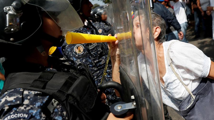 Alguns manifestantes empurraram os policiais, gritando "assassinos"; eles responderam usando spray de pimenta - Carlos Garcia/Reuters