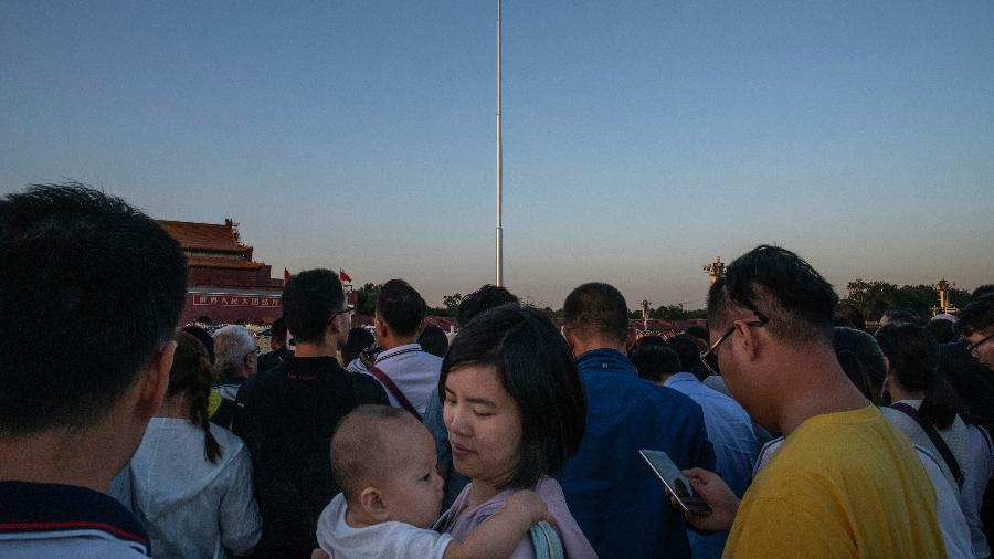 Uma mãe e seu filho na cerimônia diária de hasteamento da bandeira na Praça de Tiananmen, em Pequim - Gilles Sabrié/The New York Times