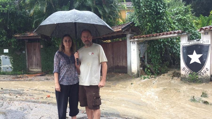 Patrícia Nobrega e Bi Ribeiro na frente da casa onde moram: "O rio passa por dentro da nossa sala e sai pela porta principal" - BBC